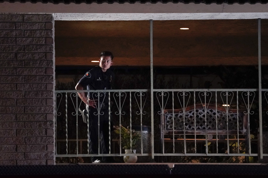 A police officer surveys the scene after a shooting at an office building in Orange, Calif., Wednesday, March 31, 2021. The shooting killed several people, including a child, and injured another person before police shot and wounded the suspect, police said. (AP Photo/Jae C.