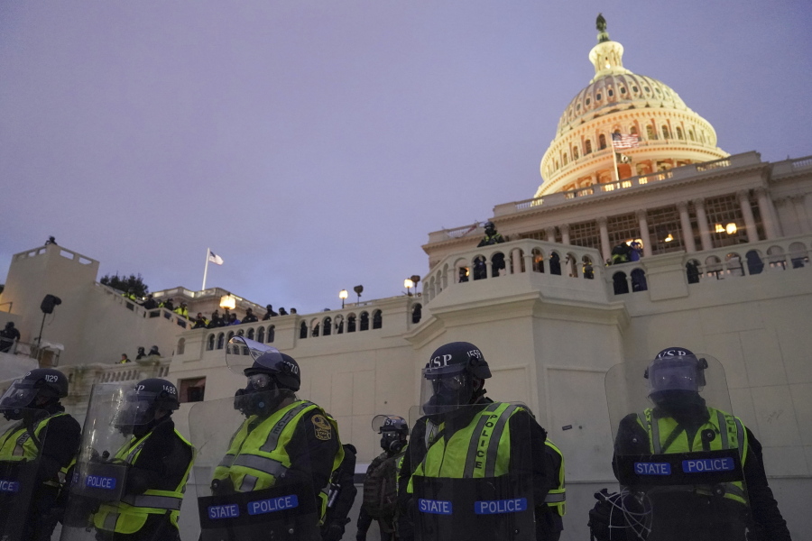 In this Wednesday, Jan. 6, 2021, photo, police form a line to guard the Capitol after violent rioters stormed the Capitol, in Washington. The top watchdog for the U.S. Capitol Police will testify to Congress for the first time about the department's broad failures before and during the Jan. 6 insurrection. Among them was missed intelligence and old weapons that officers didn't feel comfortable using.