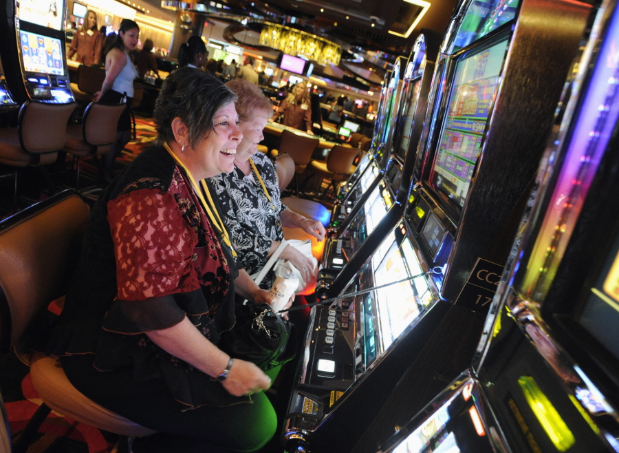 FILE - In this July 15, 2011 file photo, Karen Lingermuth, of Niles, Ill., plays the slots during a special VIP event at the Rivers Casino in the Chicago suburb of Des Plaines, Ill. Chicago is taking a big step toward building its long-awaited first casino. Starting Thursday, April 22, 2021, city officials are officially seeking bids from companies interested in what's being billed as a "world-class" resort scheduled to open by 2025.