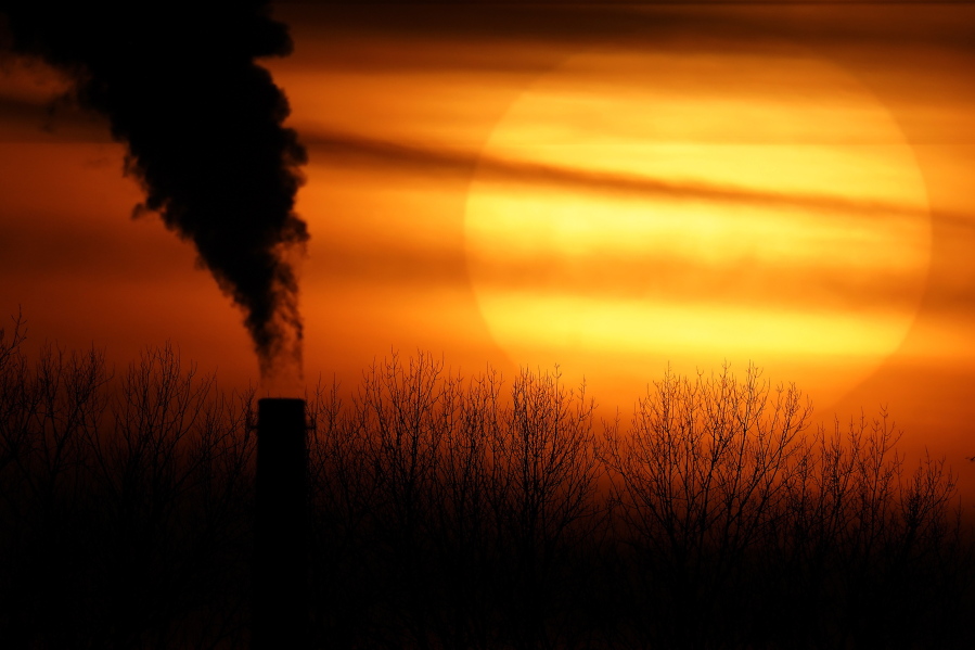 FILE - In this Feb. 1, 2021 file photo, emissions from a coal-fired power plant are silhouetted against the setting sun in Independence, Mo. President Joe Biden is convening a coalition of the willing, the unwilling, the desperate-for-help and the avid-for-money for a two-day summit aimed at rallying the world's worst polluters to do more to slow climate change. Biden's first task when his virtual summit opens Thursday is to convince the world that the United States is both willing and able isn't just willing to meet an ambitious new emissions-cutting pledge, but also able.