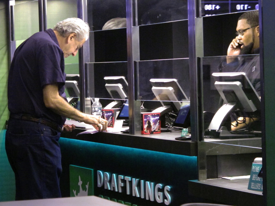 A customer makes a sports bet at the DraftKings sports book at Resorts Casino in Atlantic City, N.J. On Tuesday, March 30, 2021, DraftKings acquired the video production and distribution company Vegas Sports Information Network to add content to DraftKings' operations in 14 states.