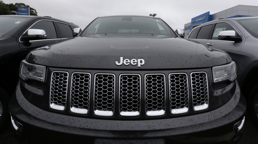 FILE - This Oct. 1, 2014, file photo, shows the hood of a Jeep Grand Cherokee at Bill DeLuca's dealerships in Haverhill, Mass. Two Italian managers in Fiat Chrysler's diesel engine program have been indicted by a federal grand jury in Detroit in a widening case alleging a scheme to cheat on U.S. emissions tests. The indictments unsealed Tuesday, April 20, 2021, detail allegations of a plot to dupe the Environmental Protection Agency by rigging more than 100,000 diesel Ram pickup trucks and Jeep SUVs to cheat on EPA tests and exceed pollution limits on real road.