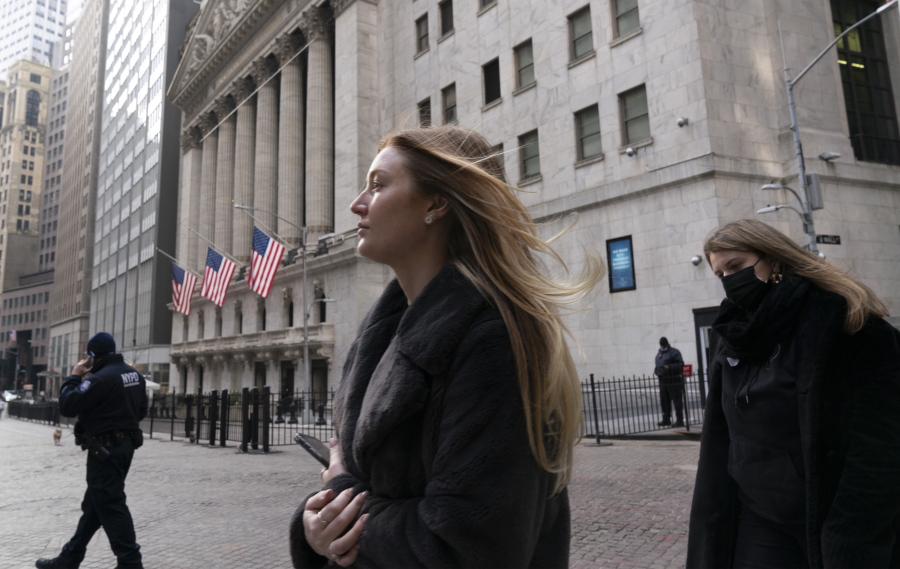 FILE - In this Jan. 13, 2021 file photo, people walk by the New York Stock Exchange.