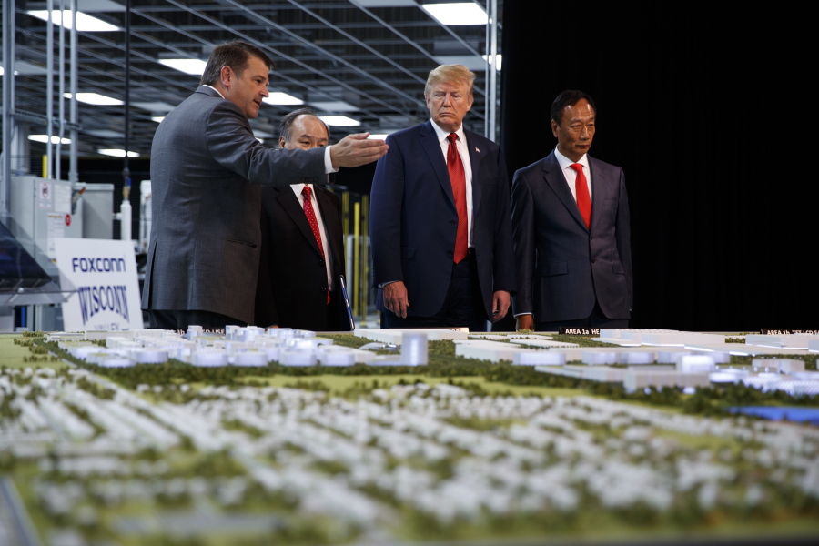 FILE - In this June 28, 2018 photo, President Donald Trump takes a tour of Foxconn with Foxconn chairman Terry Gou, right, and CEO of SoftBank Masayoshi Son in Mt. Pleasant, Wis. Foxconn Technology Group, the world's largest electronics manufacturer, has reached a new deal with reduced tax breaks for its scaled back project in southeast Wisconsin, Gov. Tony Evers and the the company announced on Monday, April 19, 2021.