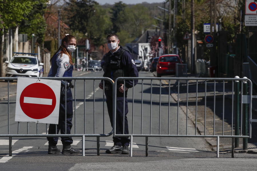 French police officers block the access next to the police station where a police official was stabbed to death Friday in Rambouillet, south west of Paris, Saturday, April 24, 2021. Anti-terrorism Investigators were questioning three people Saturday detained after the deadly knife attack a day earlier on a police official at the entry to her station in the quiet town of Rambouillet, seeking a motive, purported ties to a terrorist group and whether the attacker, killed by police, acted alone.