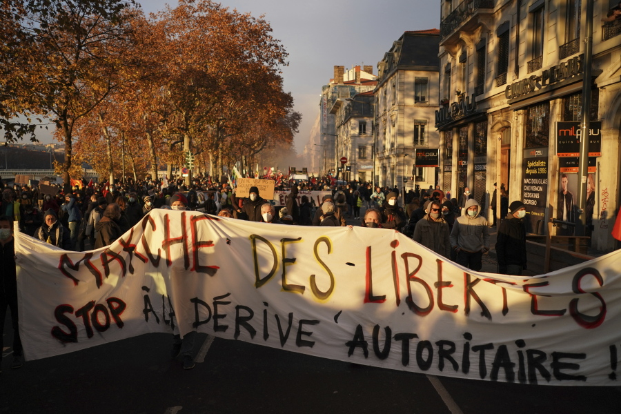 FILE - In this Dec.5, 2020 file photo, Protesters hold a banner reading 'stop to the authoritarian drift' during a demonstration in Lyon, central France.