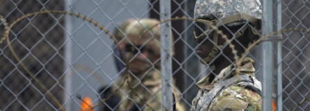 National Guard members are seen through fencing and wire near the Minneapolis Police 3rd Precinct in Minneapolis on Monday, April 19, 2021, after the murder trial against former Minneapolis police Officer Derek Chauvin advanced to jury deliberations.