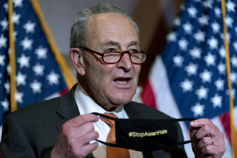 Senate Majority Leader Chuck Schumer of N.Y., holds up his mask that reads #StopAsianHate as he speaks at a news conference after the Senate passes a COVID-19 Hate Crimes Act on Capitol Hill, Thursday, April 22, 2021, in Washington.