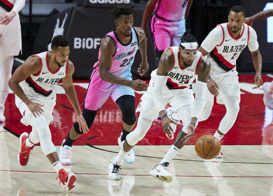 Portland Trail Blazers forward Robert Covington, second from right, leads a fast break with guard CJ McCollum, left, and forward Norman Powell, right, as Miami Heat forward Jimmy Butler trails behind during the second half of an NBA basketball game in Portland, Ore., Sunday, April 11, 2021.