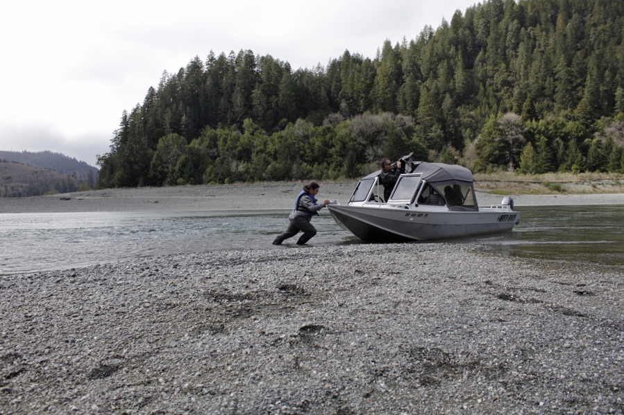 FILE - In this March 5, 2020, file photo, Hunter Maltz, a fish technician for the Yurok tribe, pushes a jet boat into the low water of the Klamath River at the confluence of the Klamath River and Blue Creek as Keith Parker, as a Yurok tribal fisheries biologist, watches near Klamath, Calif., in Humboldt County. One of the worst droughts in memory in the massive agricultural region straddling the California-Oregon border could mean steep cuts to irrigation water for hundreds of farmers this summer to sustain endangered fish species critical to local tribes. The U.S. Bureau of Reclamation, which oversees water allocations in the federally owned Klamath Project, is expected to announce this week how the season&#039;s water will be divvied up after delaying the decision a month.