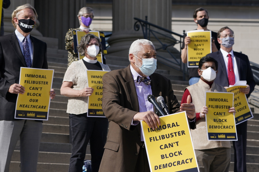 Rev. Graylan Hagler, center, speaks outside the National City Christian Church in Washington, Monday, April 5, 2021. A coalition of interfaith leaders and activists met in Washington and online to demand an end to the filibuster, calling it an arcane and racist tactic that blocks the passing of moral policies.