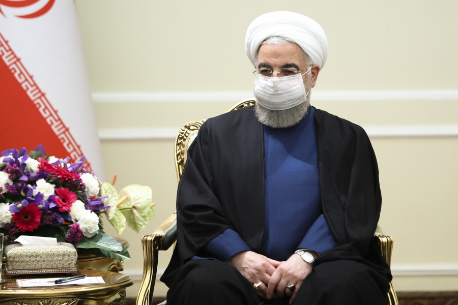 In this photo released by Russian Foreign Ministry Press Service, Iranian President Hassan Rouhani, wearing a face mask to curb the spread of COVD-19, listens to Russian Foreign Minister Sergey Lavrov during their talks in Tehran, Iran, Tuesday, April 13, 2021.