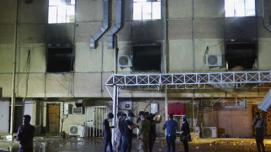 In this image made from video, first responders work the scene of a fire at a hospital in Baghdad on Saturday, April 24, 2021. The fire broke out in the Baghdad hospital that cares for coronavirus patients after oxygen cylinders reportedly exploded late Saturday, officials said.