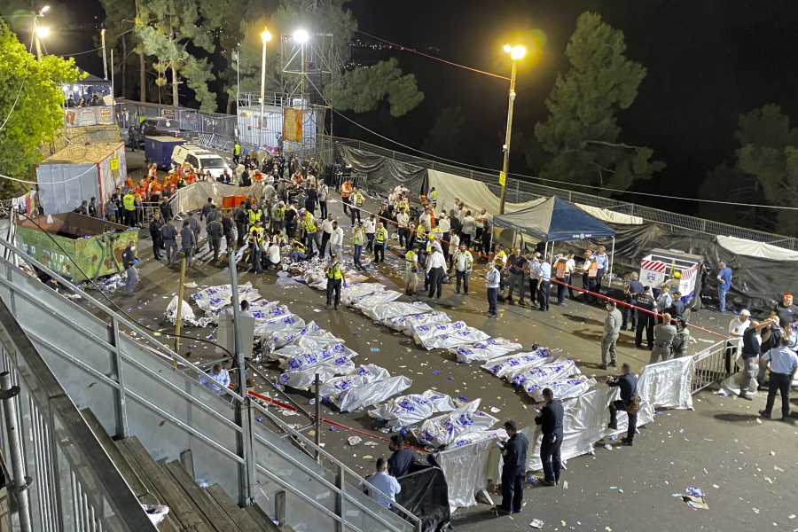 Israeli security officials and rescuers stand around the bodies of victims who died during a Lag Ba'Omer celebrations at Mt. Meron in northern Israel, Friday, April 30, 2021. The director of an Israeli ambulance service has confirmed that nearly 40 people died in a stampede at a religious festival in northern Israel.