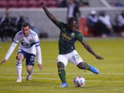 Portland Timbers forward Yimmi Chara (23) shoots as Vancouver Whitecaps midfielder Russell Teibert (31) looks on in the first half during an MLS soccer game Sunday, April 18, 2021, in Sandy, Utah.