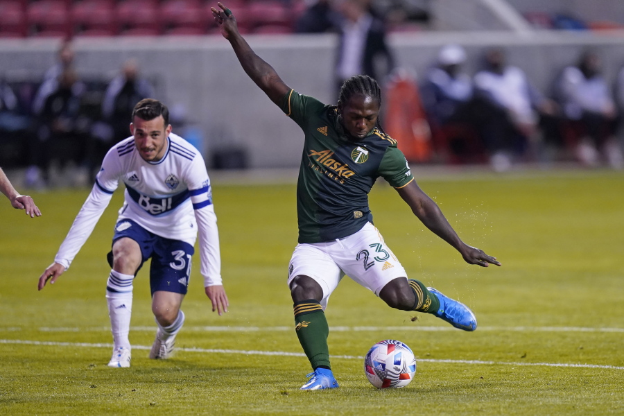 Portland Timbers forward Yimmi Chara (23) shoots as Vancouver Whitecaps midfielder Russell Teibert (31) looks on in the first half during an MLS soccer game Sunday, April 18, 2021, in Sandy, Utah.