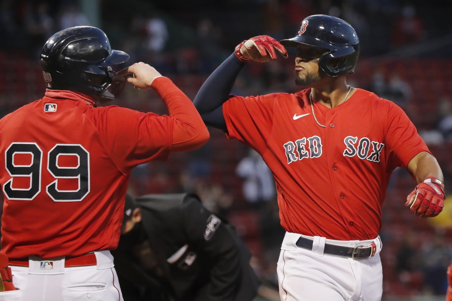 Boston Red Sox's Xander Bogaerts celebrates his two-run home run that also drove in Alex Verdugo (99) during the first inning of a baseball game against the Seattle Mariners, Friday, April 23, 2021, in Boston.