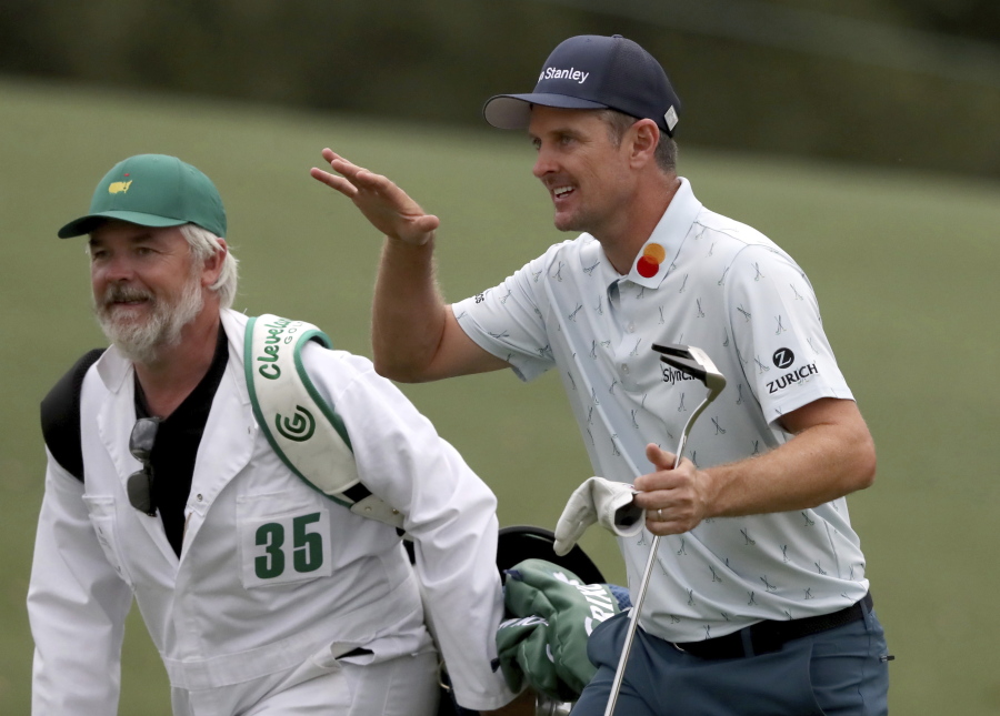 Justin Rose and his caddie David Clark react to his second shot on the eighteenth hole during the first round of the Masters golf tournament at Augusta National Golf Club, Thursday, April 8, 2021, in Augusta, Ga.