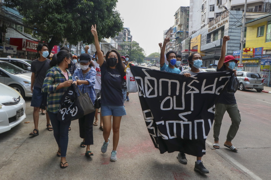 Anti-coup protesters shout slogan with a banner reading ''Carry on revolution! We do not accept as the military slave,'' in Kamayut township of Yangon, Myanmar, Monday, April 19, 2021. Anti-coup protesters kept public demonstrations going despite the threat of lethal violence from security forces.