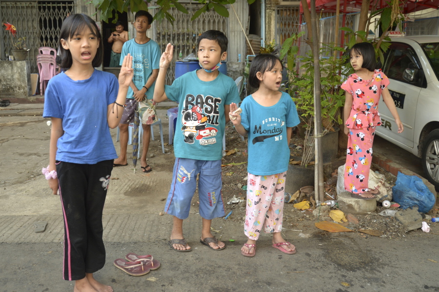 Children flash the three-fingered symbol of resistance as they join an anti-coup protest in Yangon, Myanmar, Saturday, April 10, 2021.