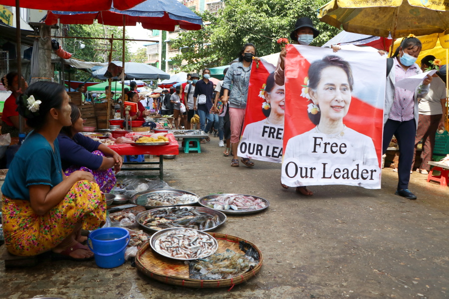 Anti-coup protesters walk through a market with images of ousted Myanmar leader Aung San Suu Kyi at Kamayut township in Yangon, Myanmar Thursday, April 8, 2021. They walked through the markets and streets of Kamayut township with slogans to show their disaffection for military coup.