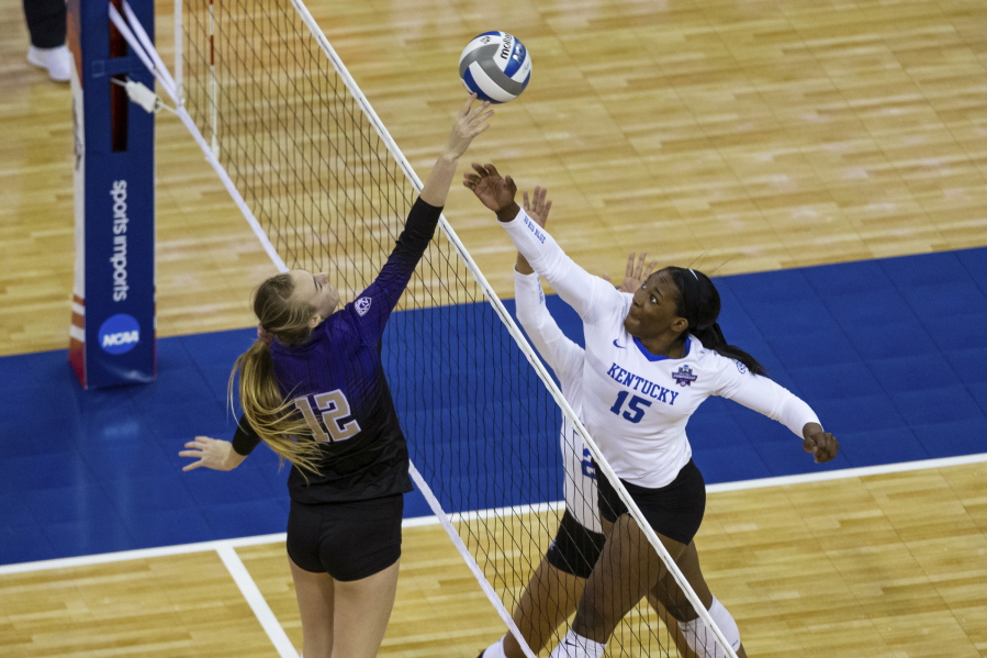 Washington's Marin Grote (12) bumps the ball over Kentucky's Azhani Tealer (15) during the first set of a semifinal in the NCAA women's volleyball championships Thursday, April 22, 2021, in Omaha, Neb.