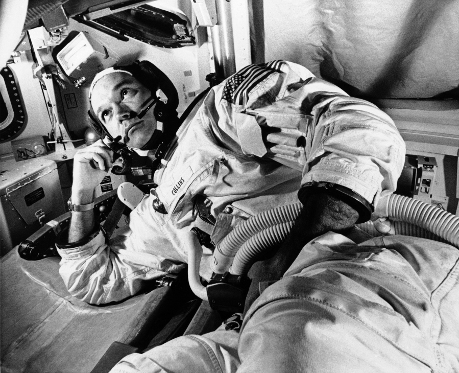 FILE - In this July 24, 1969 file photo, President Richard Nixon, back to camera, greets the Apollo 11 astronauts in a quarantine van on board the U.S.S. Hornet after splashdown and recovery in the Pacific Ocean. From left are Neil Armstrong, Michael Collins, and Edwin "Buzz" Aldrin. Splashdown was east of Wake Island, and south of Johnston Atoll. Collins, who piloted the ship from which Armstrong and Aldrin left to make their historic first steps on the moon in 1969, died Wednesday, April 28, 2021, of cancer, his family said. He was 90.