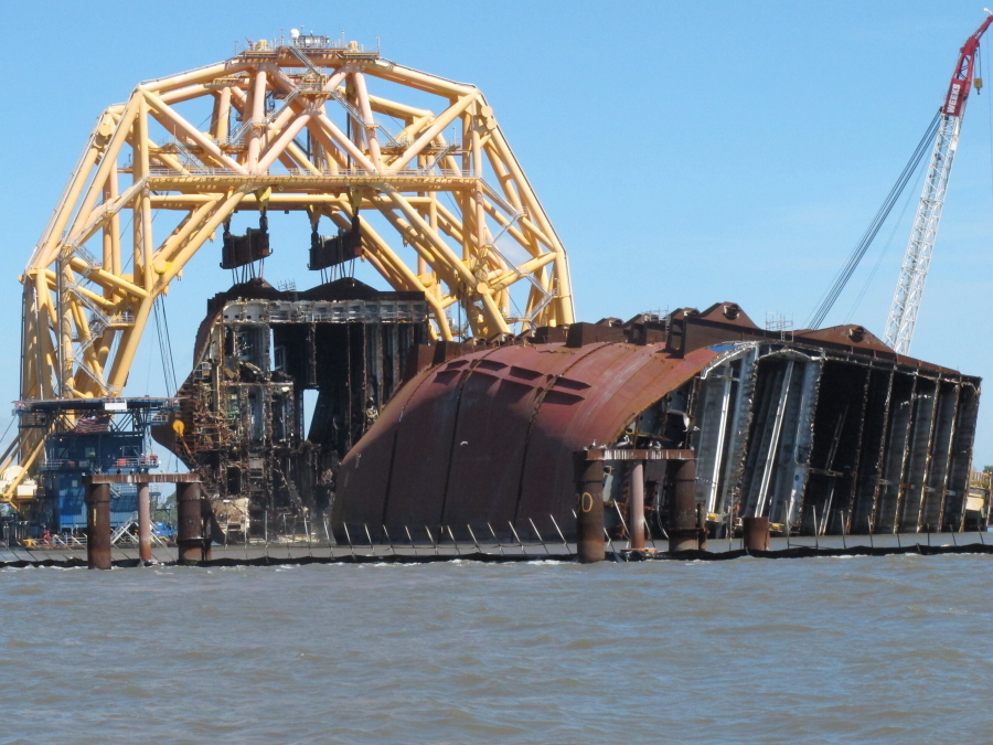 A towering crane pulls the engine room section away from the remains of the capsized cargo ship Golden Ray on Monday, April 26, 2021, offshore of St. Simons Island, Ga. The South Korean vessel capsized with roughly 4,200 vehicles in its cargo decks in September 2019. The engine room section is the fourth giant chunk of the ship to be cut away and removed since demolition began in November 2020.