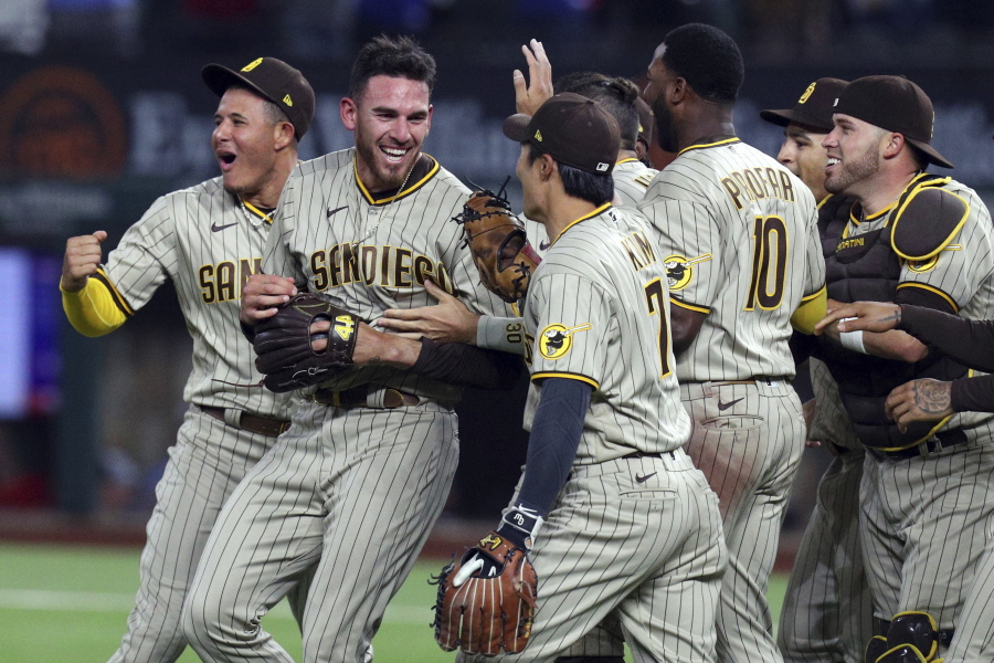 San Diego Padres starting pitcher Joe Musgrove, second from left, is mobbed by teammates after pitching a no-hitter against the Texas Rangers in a baseball game Friday, April 9, 2021, in Arlington, Texas. (AP Photo/Richard W.