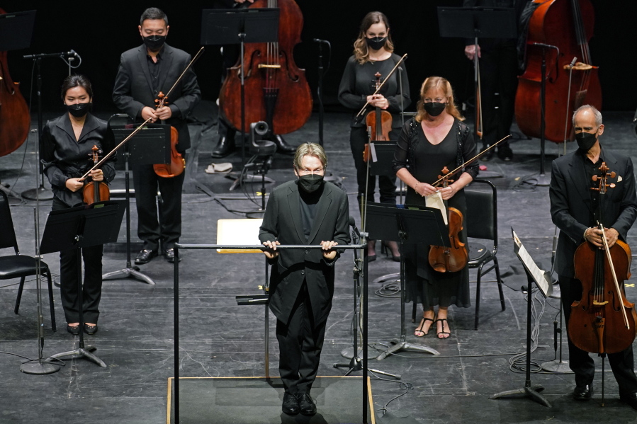 Guest conductor Esa Pekka Salonen, front center, greets a live audience as New York Philharmonic musicians stand behind him before they performed together for the first time since March 10, 2020, at The Shed in Hudson Yards, Wednesday, April 14, 2021, in New York. Normal subscription performances are scheduled to resume in September.