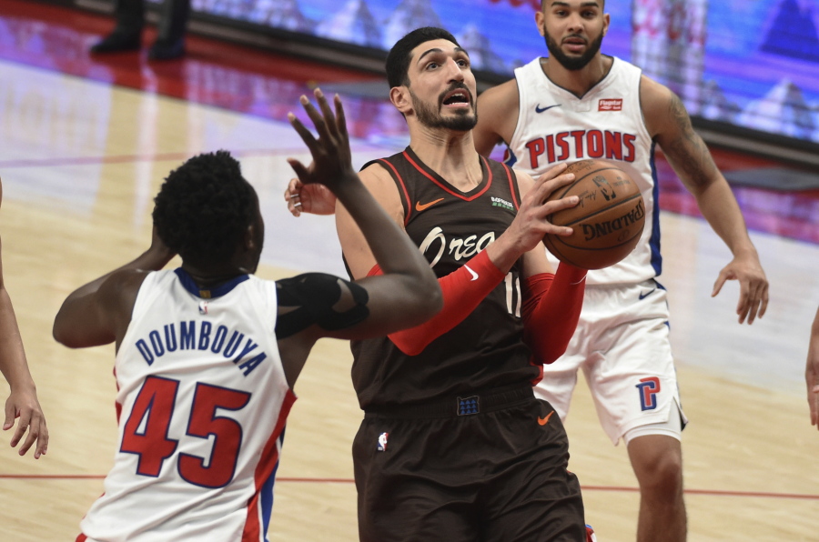 Portland Trail Blazers center Enes Kanter drives to the basket on Detroit Pistons forward Sekou Doumbouya, left, during the second half of an NBA basketball game in Portland, Ore., Saturday, April 10, 2021. The Blazers won 118-103.