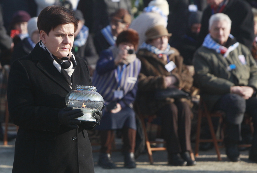 FILE - In this Friday, Jan. 27, 2017 file photo, Polish Prime Minister Beata Szydlo lights a candle at the International Monument to the Victims of Fascism, after a ceremony marking the 72nd anniversary of the liberation of the German Nazi death camp Auschwitz-Birkenau, in Oswiecim, Poland. Three of nine members appointed to an advisory council for the Auschwitz-Birkenau museum in Poland have resigned in protest after the government also named Beata Szydlo, a top right-wing ruling party member, to serve on the body it was announced Friday, April 16, 2021. The culture minister appointed Szydlo recently to a four-year term on the Auschwitz-Birkenau State Museum Council, a body made up of Poles who meet once a year to advise the director but which has little real influence.