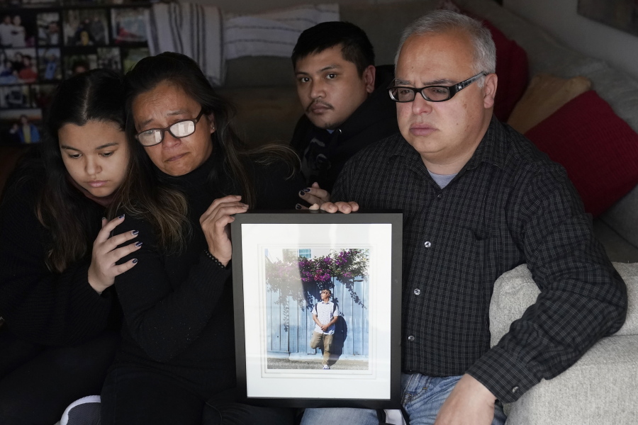 Cassandra Quinto-Collins, second from left, holds a photo of her son, Angelo Quinto, while sitting with daughter Bella Collins, left, son Andrei Quinto, center, and husband Robert Collins during an interview in Antioch, Calif., Tuesday, March 16, 2021. Angelo Quinto died three days after being restrained on Dec. 23, 2020, in police custody while having a mental health crisis. Lawmakers in several states are proposing legislation that would require more training for police in how to interact with someone in a mental crisis following some high-profile deaths.