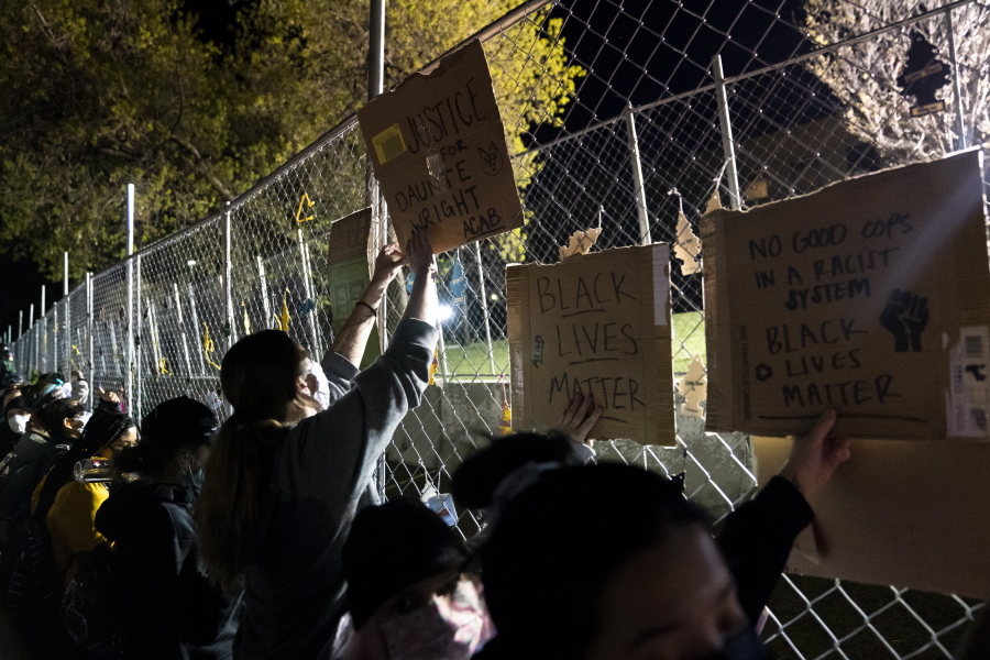 Demonstrators press against a perimeter security fence during a protest over the fatal shooting of Daunte Wright during traffic stop, outside the Brooklyn Center Police Department, Friday, April 16, 2021, in Brooklyn Center, Minn.