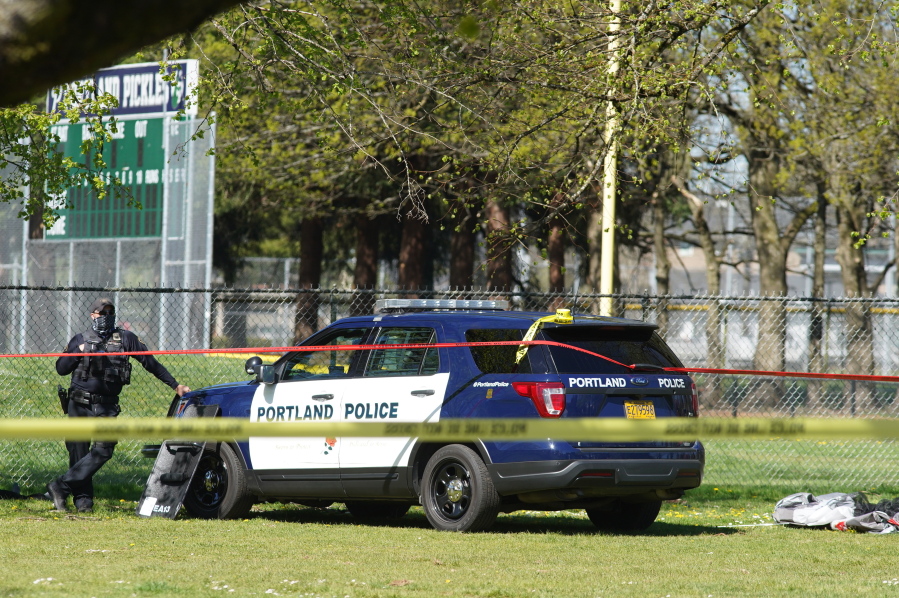 A Portland Police officer stand by following a police involved shooting of a man at Lents Park, Friday, April 16, 2021, in Portland, Ore. Police fatally shot a man in the city park Friday morning after responding to reports of a person with a gun, authorities said.
