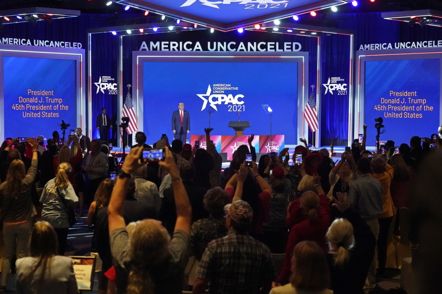 FILE - In this Feb. 28, 2021, file photo supporters cheer and wave as former president Donald Trump is introduced at the Conservative Political Action Conference (CPAC) in Orlando, Fla.