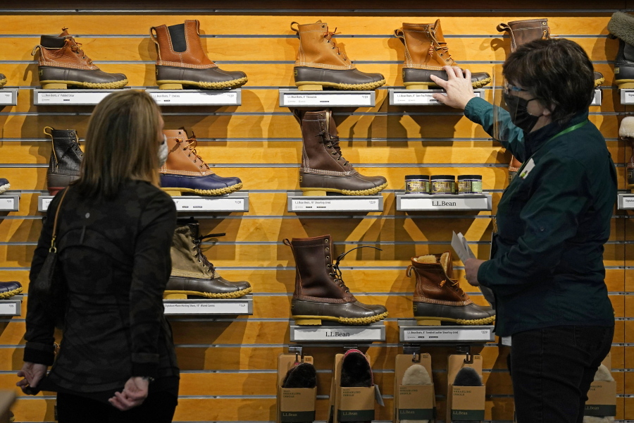 A salesperson helps a customer shopping for boots at the L.L. Bean flagship retail store in Freeport, Maine, on March 18. Newly vaccinated and armed with $1,400 stimulus checks, Americans went on a spending spree last month, buying new clothes and going out to eat again, the Commerce Department said Thursday. (robert f.