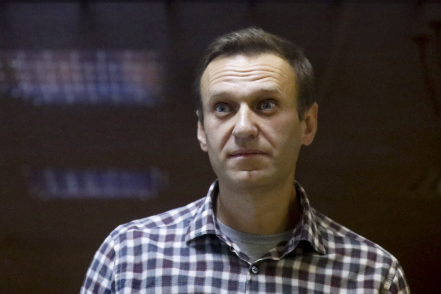 FILE - In this Saturday, Feb. 20, 2021 file photo, Russian opposition leader Alexei Navalny stands in a cage in the Babuskinsky District Court in Moscow, Russia. Imprisoned Russian opposition leader Alexei Navalny, who has been on hunger strike since March 31, described threats to force-feed him, using "straitjacket and other pleasures," in a message from behind bars Friday, April 16. In an Instagram post, Navalny said an official told him that a blood test indicated his health was deteriorating and threatened to force-feed him if he continues to refuse to eat.