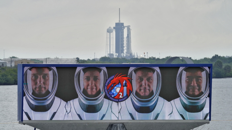 Members of the SpaceX Crew 2, from left, Thomas Pesquet, of the European Space Agency, NASA astronauts Megan McArthur, Shane Kimbrough, and Akihiko Hoshide, of the Japan Aerospace Exploration Agency, are shown on a video screen as the SpaceX Falcon 9 with the crew Dragon capsule sits on Launch Complex 39A Wednesday, April 21, 2021, at the Kennedy Space Center in Cape Canaveral, Fla. Four astronauts will fly on the SpaceX Crew-2 mission to the International Space Station scheduled for launch on April 23, 2021.