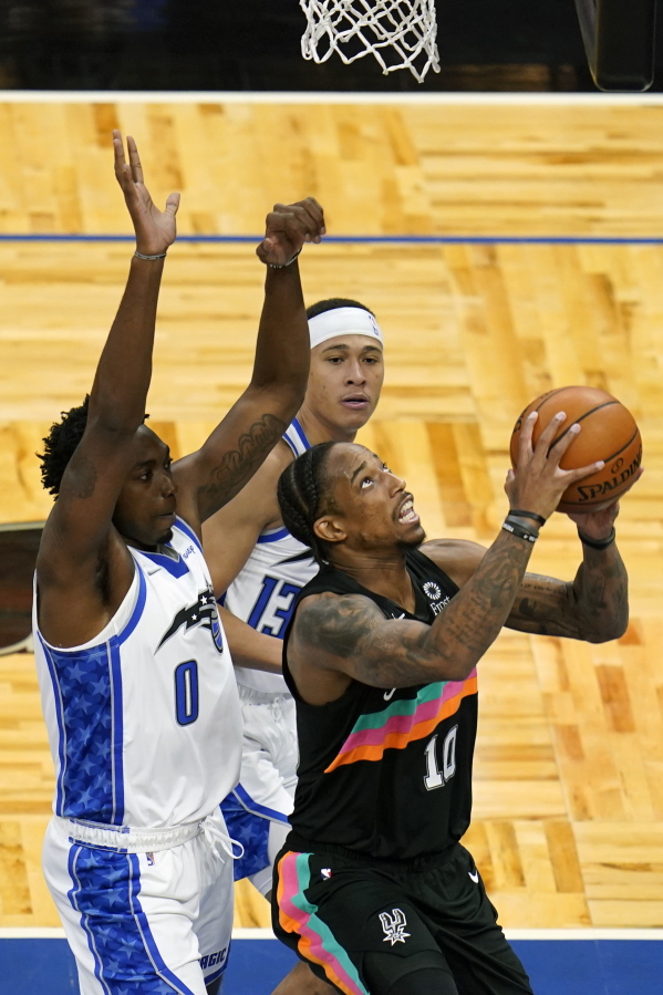 San Antonio Spurs forward DeMar DeRozan, right, looks for a shot against Orlando Magic&#039;s Robert Franks (0) and guard R.J. Hampton, back center, during the second half of an NBA basketball game, Monday, April 12, 2021, in Orlando, Fla.
