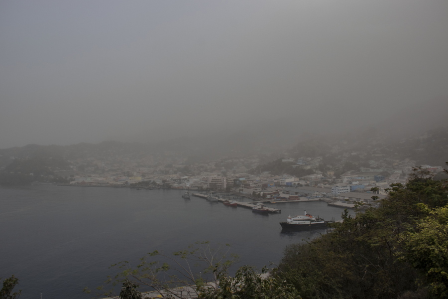 A cloud of volcanic ash hovers over Kingstown, on the eastern Caribbean island of St. Vincent, Saturday, April 10, 2021, a day after the La Soufriere volcano erupted.