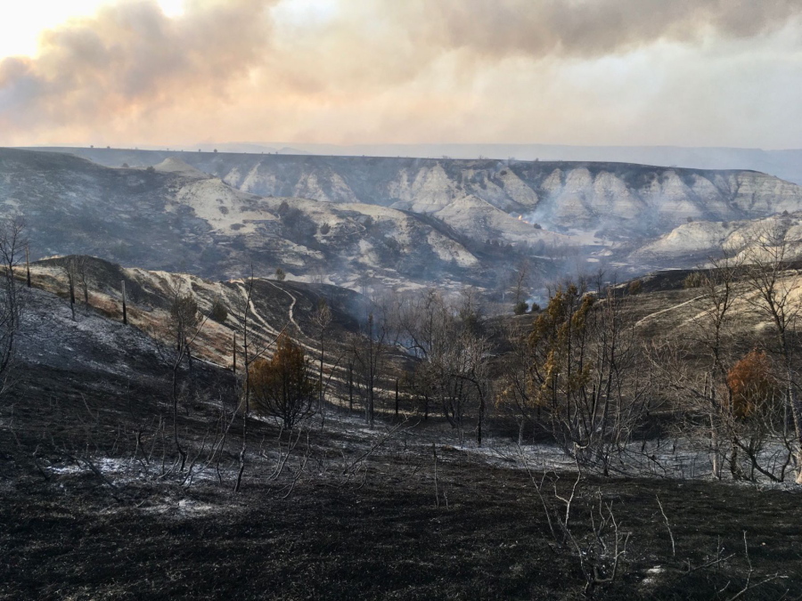 A wildfire smolders near the Burning Hills Amphitheatre Thursday, April 1, 2021 near Medora, N.D. Officials say firefighters have stopped a wildfire from spreading in the western North Dakota tourist town of Medora, where its 100 residents were forced to evacuate.