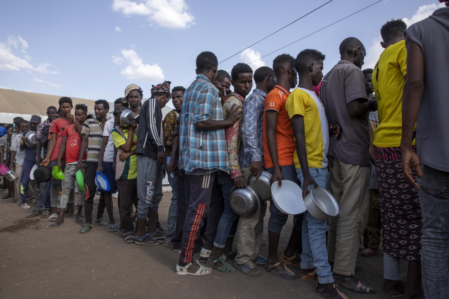 Tigrayan refugees wait in line to revive food from Muslim Aid at Hamdeyat Transition Center near the Sudan-Ethiopia border, eastern Sudan, Wednesday, March 24, 2021.
