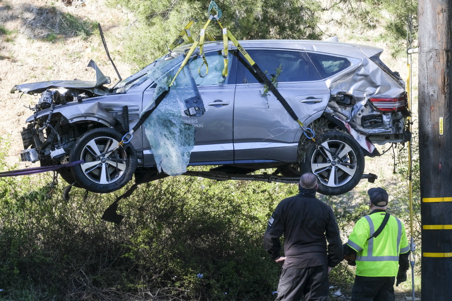 FILE - In this Feb. 23, 2021, file photo, a crane is used to lift a vehicle following a rollover accident involving golfer Tiger Woods, in the Rancho Palos Verdes suburb of Los Angeles. The Los Angeles County sheriff plans to announce Wednesday, April 7, 2021, what caused Woods to crash an SUV in Southern California earlier in the year, seriously injuring himself in the wreck. (AP Photo/Ringo H.W.
