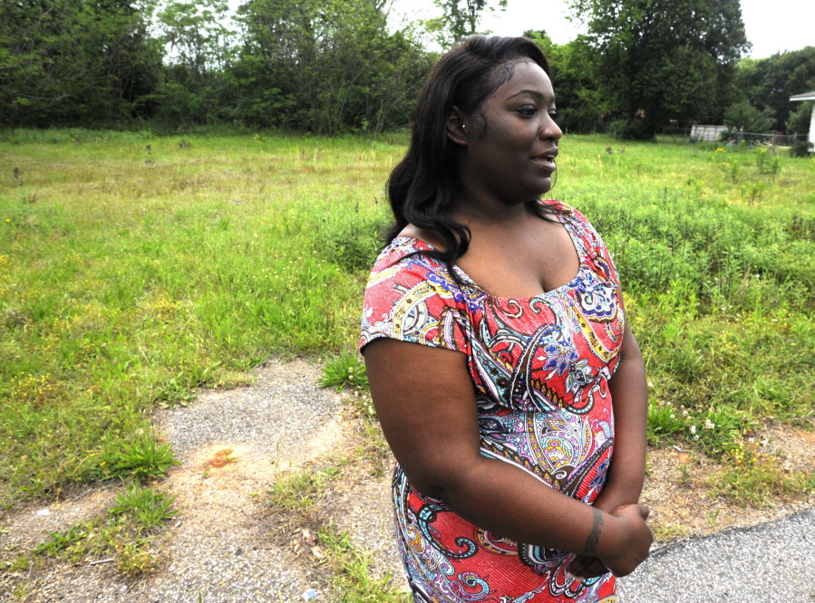 Markedia Wells stands April 14 at the now-empty lot in Tuscaloosa, Ala., where she and her two sons survived a tornado a decade ago.