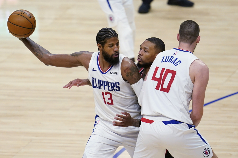 Los Angeles Clippers guard Paul George (13) holds the ball as Ivica Zubac (40) sets a screen on Portland Trail Blazers guard Damian Lillard, center, during the second half of an NBA basketball game Tuesday, April 6, 2021, in Los Angeles.