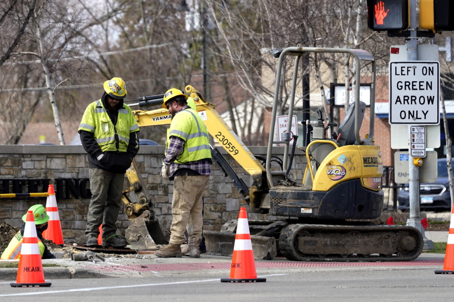 Construction workers work in Wheeling, Ill., Wednesday, March 31, 2021. President Joe Biden will unveil his $2 trillion infrastructure plan and the plan aims to revitalize U.S. transportation infrastructure, water systems, broadband and manufacturing, among other goals. (AP Photo/Nam Y.