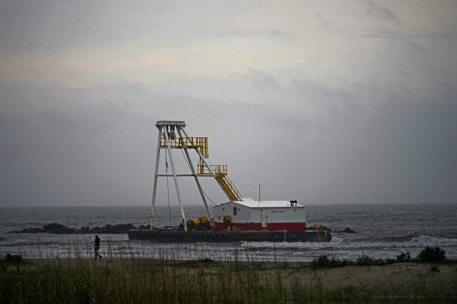 A man who did not want to be identified surveys his company's barge that ran aground during a storm on Tuesday, that also capsized a lift boat, killing one with 12 others still missing in the Gulf of Mexico, in Grand Isle, La., Thursday, April 15, 2021.
