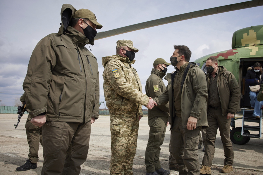 Ukrainian President Volodymyr Zelenskiy shakes hands a soldier as he visits the war-hit Donetsk region, eastern Ukraine, Thursday, April 8, 2021. Ukraine is at the center of a major geopolitical battle in the eastern part of the country with Moscow backed separatists.