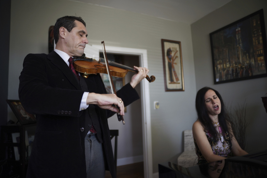 Musicians David Shenton and Erin Shields perform inside their home in the Queens borough of New York on March 30, 2021. The married couple have led virtual concerts from their living room to raise thousands of dollars for the Mosaic West Queens Church food pantry, where they volunteer every weekend.